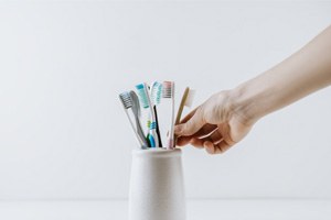 picking up one of several toothbrushes in a holder