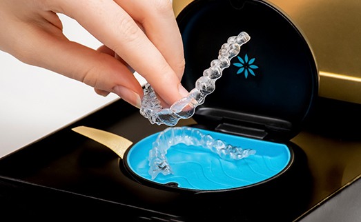 A woman putting Invisalign trays in a case