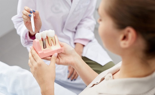 A dentist explaining dental implant care in Carlisle