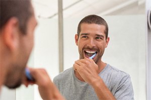 A happy man brushing his teeth