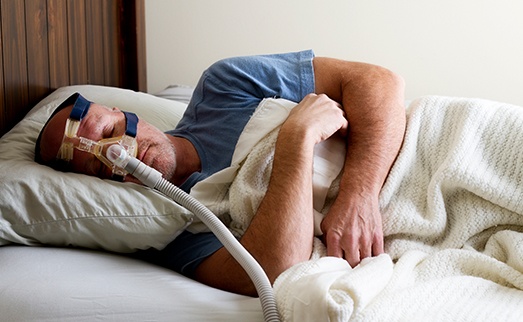 Sleeping man with CPAP mask